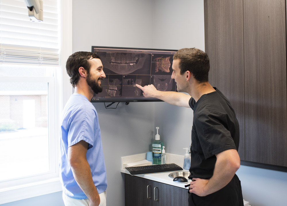 Dr. Jon Byrd and Dr. Preston Ford of Byrd Ford Dentistry standing near screen in exam room